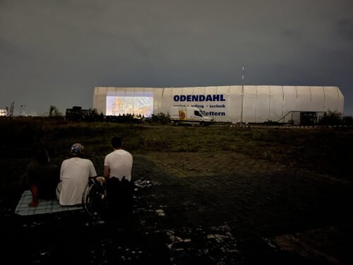 Zeigt 2 Kinobesucher und die Kinoleinwand auf dem Kalkberg